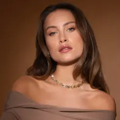 Kvinna bär Caroline Svedbom Mini Pomona halsband i guld med kristaller