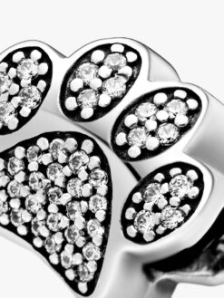 Detaljbild av berlock med glittrande tassavtryck