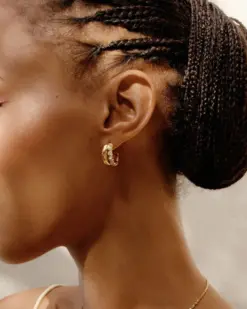 Detaljbild av guldpläterade stora hoop-örhängen