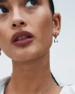 Detaljbild av rostfria hoop-örhängen med hjärtdesign