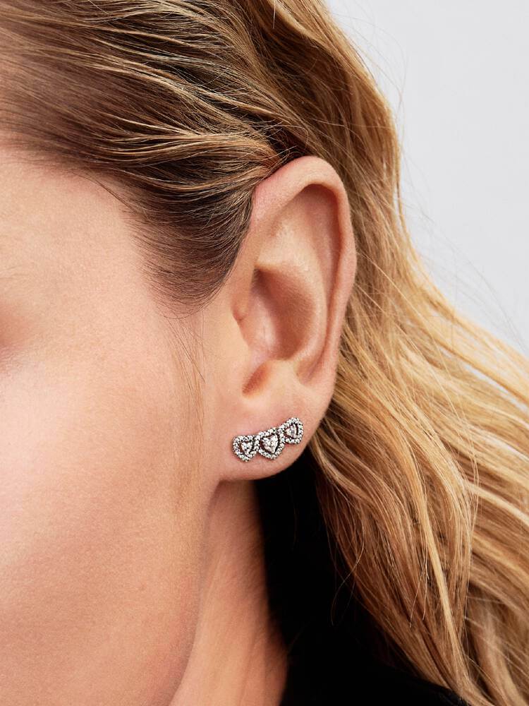 Detaljbild av stiftörhänge med tre hjärtformade stenar