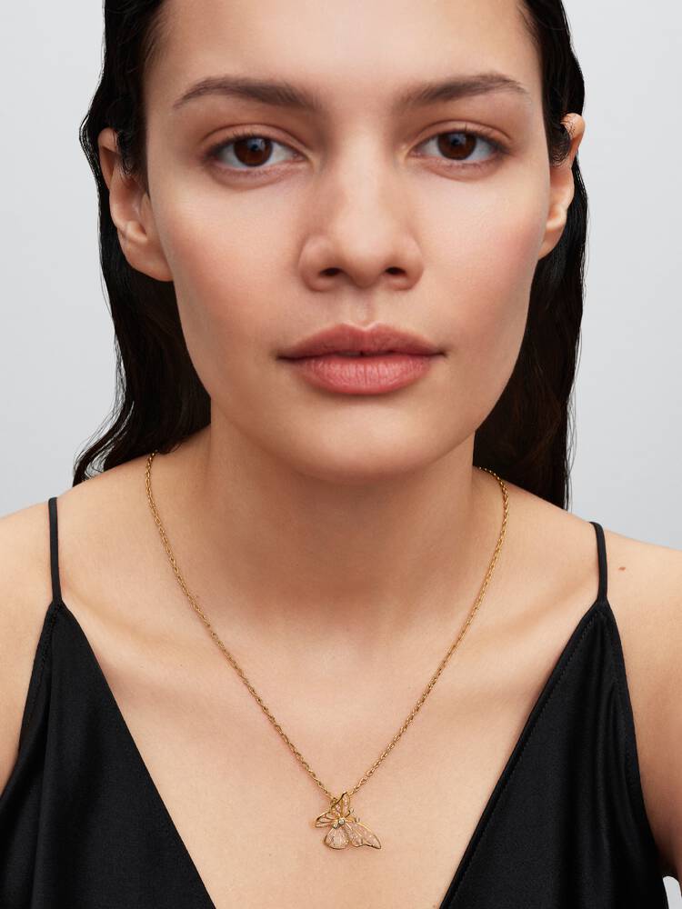 Pandora Moments fjärilsberlock i guld på modell på en kedja