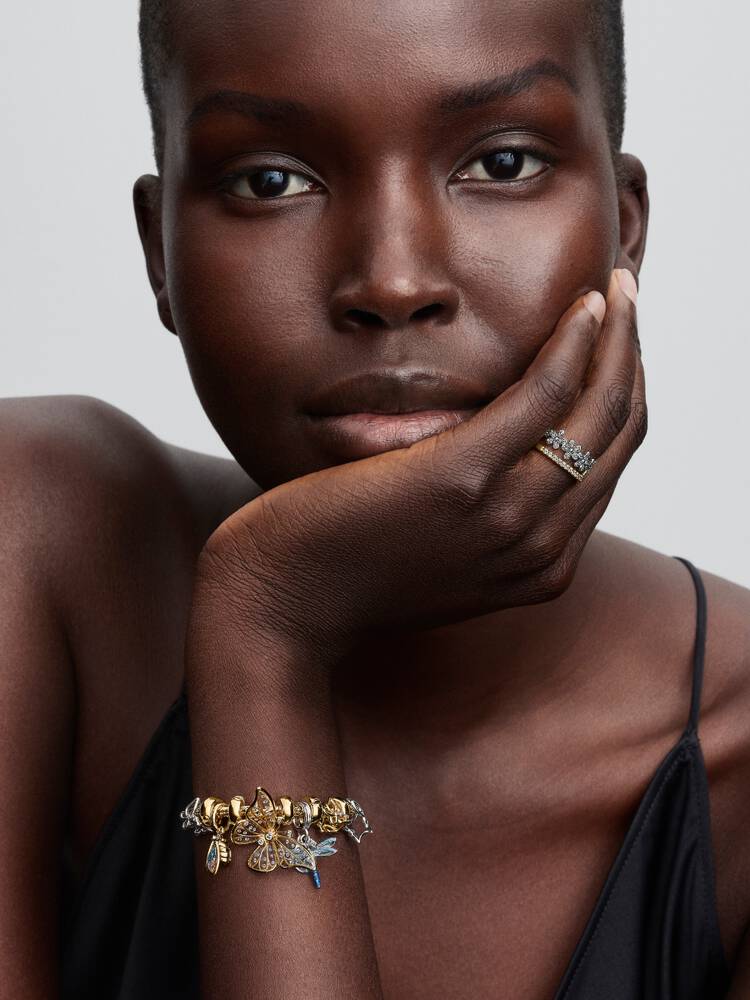 Pandora Moments fjärilsberlock i guld på modell med ormkedjearmband