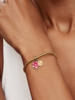 Pandora Disney Vaiana-blomma hängberlock på modell med Moments-armband i guld – Disney x Pandora