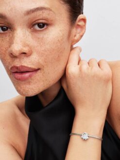 Pandora yeti-berlock i vit emalj buren på Moments-armband runt handleden
